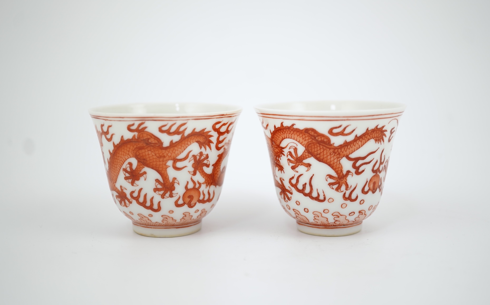 A pair of Chinese iron red ‘dragon’ cups, Guangxu six character mark and probably of the period (1875-1908)